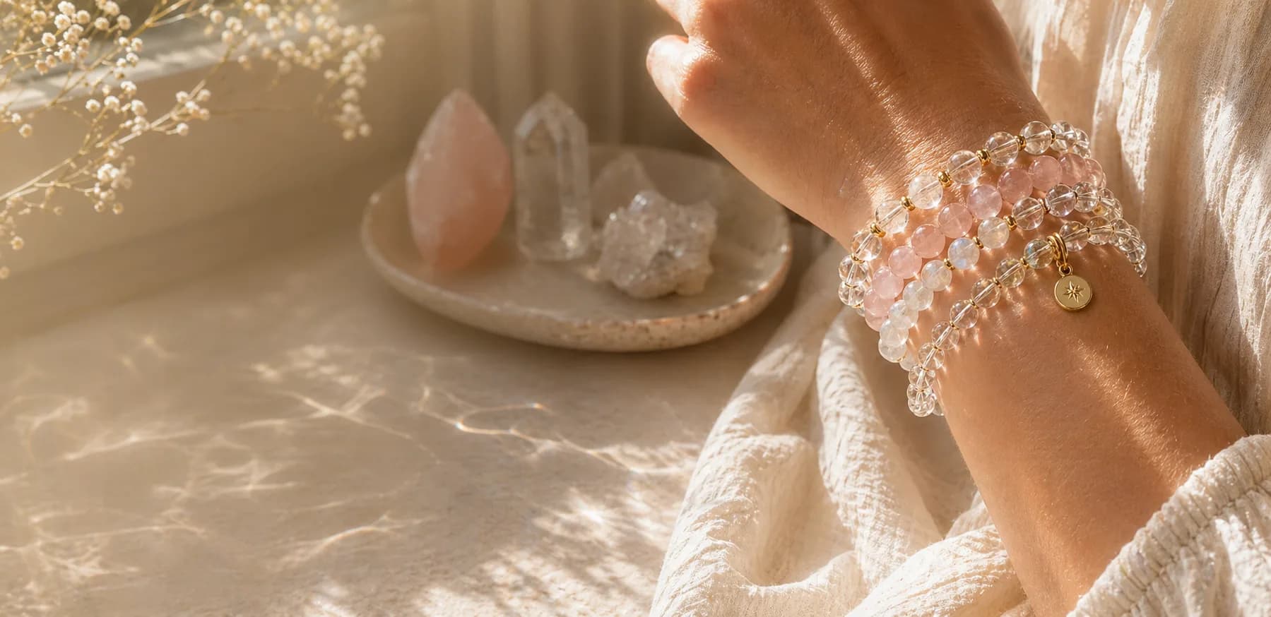 Layered crystal bracelets catching warm sunlight